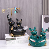 Two sets of decorative dog figurines with sunglasses on a surface.