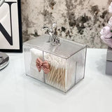 Clear glass matchbox with decorative lid on a white surface