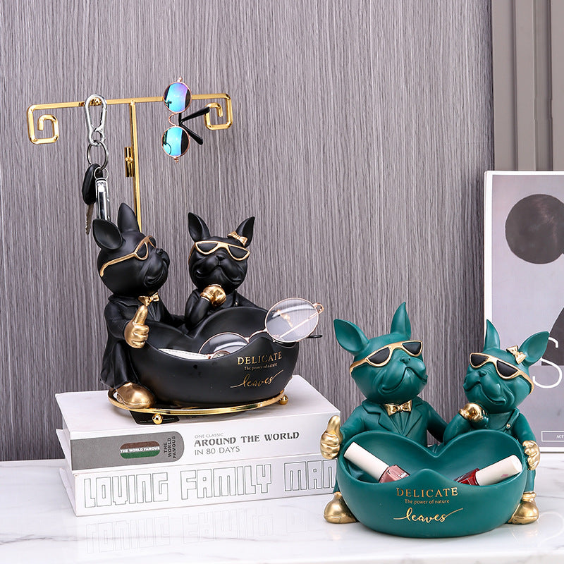 Two sets of decorative dog figurines with sunglasses on a surface.